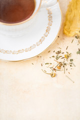 Elizabethan Bone China Tea Cup and Saucer with Herbal Tea and Tea Infuser on Yellow Background