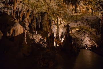 View of stalactites and stalagmites in an underground cavern - Postojna cave in Slovenia