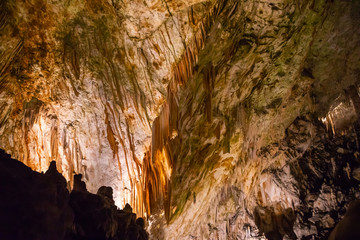 View of stalactites and stalagmites in an underground cavern - Postojna cave in Slovenia