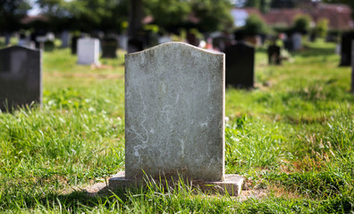 Blank gravestone with other graves and trees in background. Old stone. - obrazy, fototapety, plakaty