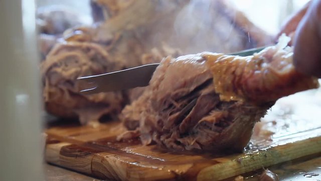Carving the leg of a turkey close up, in slow motion