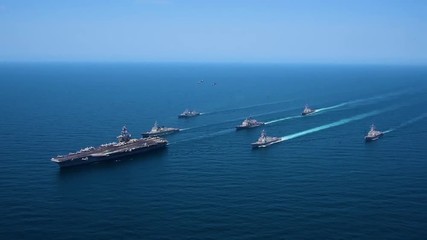 Very good aerial over a fleet of Amercian warships at sea.