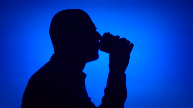 Silhouette of senior man with coffee to go on blue background. Male's face in profile drinking coffee from paper cup. Black contur shadow of grandfather's half-face