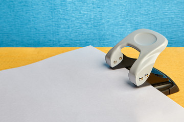 White sheet of paper and punch, mockup with copy-space.