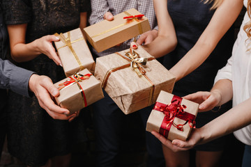 Christmas party, New Year celebration, sale, black friday, holiday, fun, togetherness. Group of people with presents. Close up hands opening gift boxes