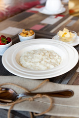 Healthy breakfast. Rice porridge bowl with berries and nuts on the table, hot and healthy breakfast food, side view