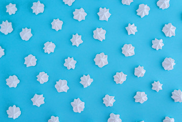 Fototapeta na wymiar White meringues on blue background
