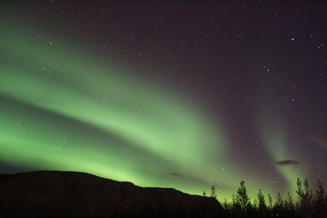 Aurora boreal, luces del norte, verdes en el cielo otoñal islandés.