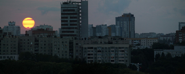 Panoramic view of sunset in city with big yellow sun on horizon. Minsk, Belarus