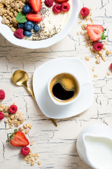 Granola with berries, yoghurt and coffee for breakfast. Cereal oats with strawberries, blueberries and raspberries for healthy eating. Top view