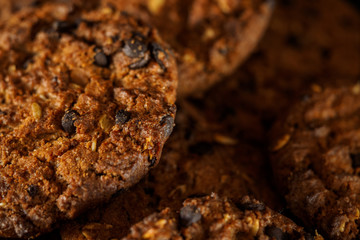 Chocolate chip cookies on rustic dark black background. Stacked chocolate chip cookies on brown napkin. Symbolic image with place for text. Freshly baked. Concept for a tasty snack. Sweet dessert