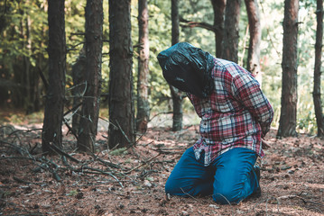 man with a package on his head in the forest