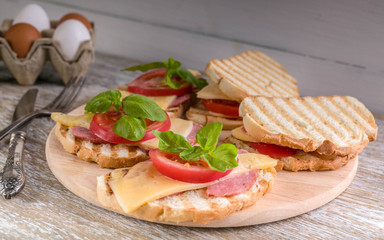 Sandwiches with sausage, cheese, tomato and basil