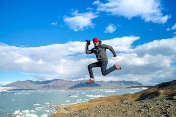 Happy Man jumping on small hill near Jokulsarlon.