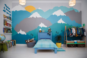 A spacious boy bedroom with a beautiful turquoise and grey mountain wall mural and bookshelves - obrazy, fototapety, plakaty
