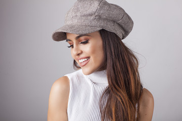 Beautiful brunette in the hat in front of camera.