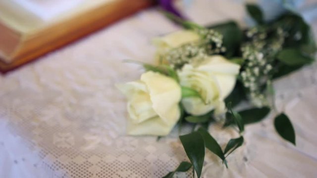 Close up of a couple white roses on a table in a church