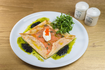 Salmon wrapped in pancake with cream cheese and pesto sauce