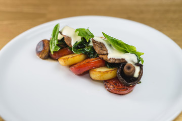 vegetables and mushrooms grilled with basil, on a white plate