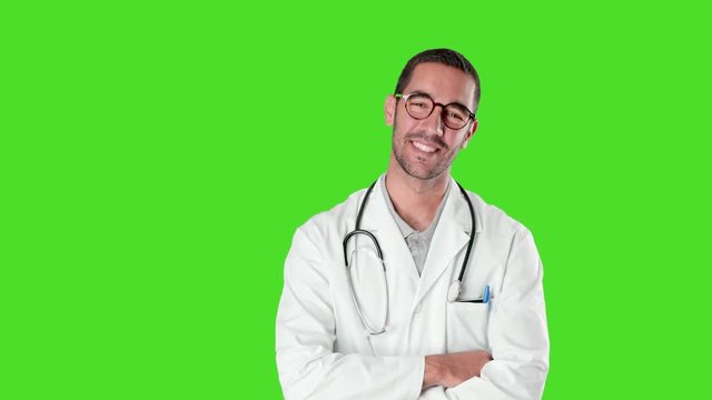Confident young doctor with crossed arms gesture against green background