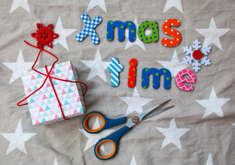 Flat lay with wrapping gift box scissors and words xmas time. Christmas background pattern.