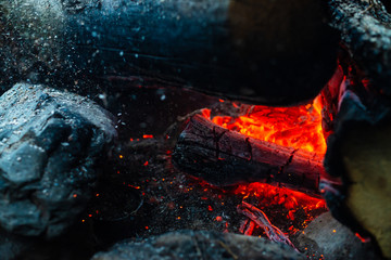 Smoldered logs burned in vivid fire. Atmospheric background with orange flame of campfire....