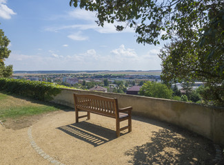 Fototapeta na wymiar wooden bench for relaxing in castle park with a view on Benatky nad Jizerou