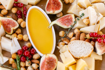Light Italian snacks. A buffet table at a dinner party. Cheese plate. Delicious cheese mix on wooden table. Tasting dish on a wooden plate. Food for wine.