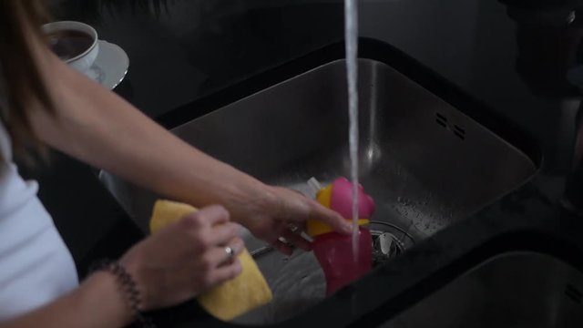 Mom washes the baby dishes