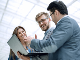 close up. smiling business team looks at the laptop screen
