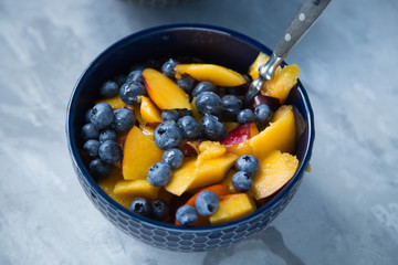 Breakfast bowl with oat flakes and fruits and berries like blueberries , nectarines and bananas