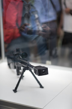 Long sniper rifle on bipod. a man makes a photo on the phone