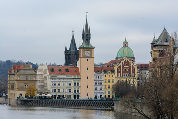 View of the left bank of the Vltava River in Prague, Old place, Old Town water tower. The tower with an elongated pointed spire and narrow Gothic turrets. Near the Old Town Bridge Tower. 