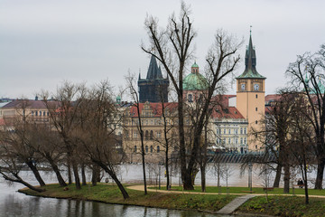 View of the left bank of the Vltava River in Prague, Old place, Old Town water tower. The tower with an elongated pointed spire and narrow Gothic turrets. Near the Old Town Bridge Tower. 