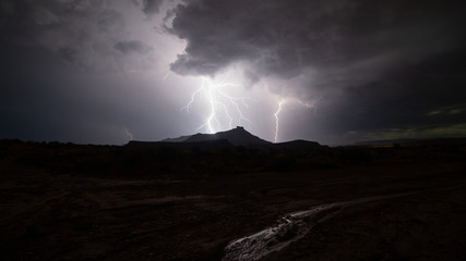 Gooseberry mesa in Southern Utah is silhouetted by lightning on a dark stormy summer night. Run off...