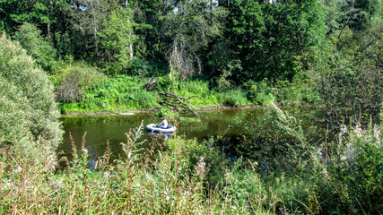 Inflatable boat in the river among the forest