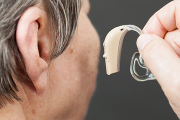 Fototapeta premium Closeup senior woman using hearing aid