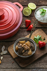Massaman Beef Curry Served In copper pan, wooden background