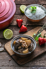 Massaman Beef Curry Served In copper pan, wooden background