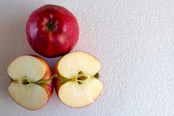 an isolated red apple and two half apples on a white background