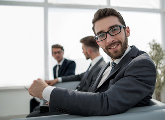 portrait of a successful businessman sitting in the lobby of the business center