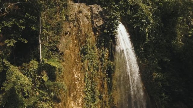 aerial footage waterfall in the mountains. Waterfall flowing on the slopes of mountains covered with tropical vegetation. Philippines, Luzon