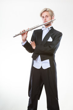 Male flutist wearing tailcoat holds flute
