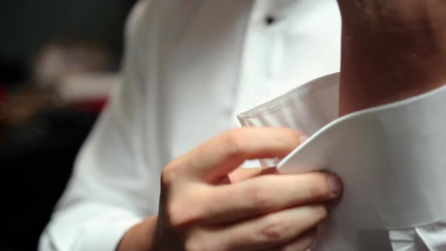 Inserting a cuff link into a white dress shirt, CU