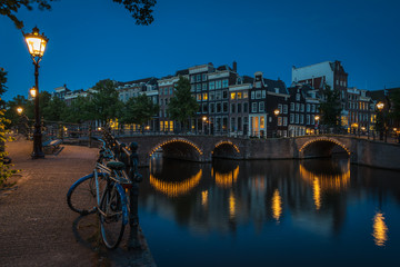 Obraz premium The lonely bike beside the canals at night, Amsterdam, the Netherlands