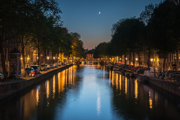 Fototapeta premium The moon reflected in the canal at night, Amsterdam, the Netherlands