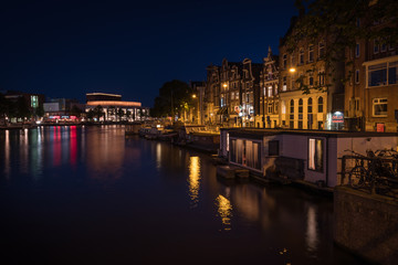 Fototapeta premium Reflection of the illuminated city of Amsterdam at night , Amsterdam, Netherlands.