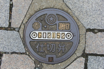 地面に設置された「仕切弁」の金属製の蓋(福岡県)