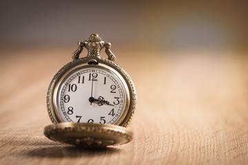 Pocket watch on wooden background.