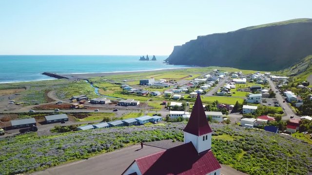 Aerial establishing shot of the town of Vik in Southern Iceland its iconic church.